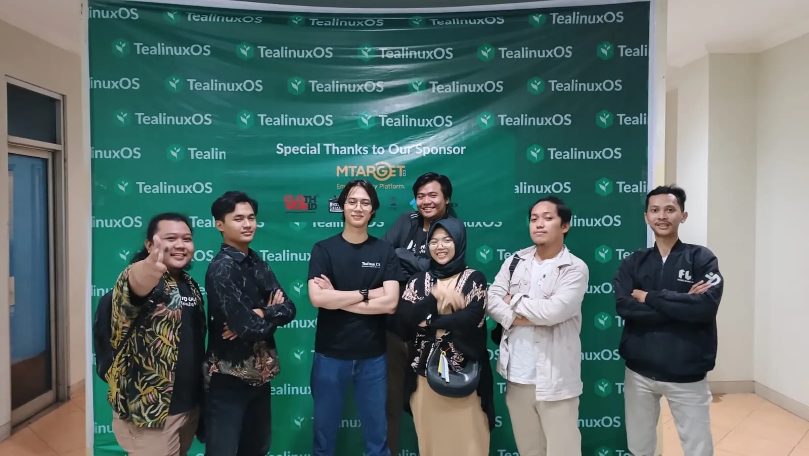 Dinus Open Source Community members in 2022 in front of a Tealinux OS banner